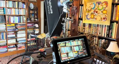 Camera monitor and softbox lighting setup inside a library room