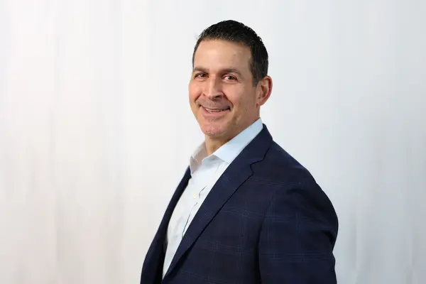 Professional headshot — navy suit profile